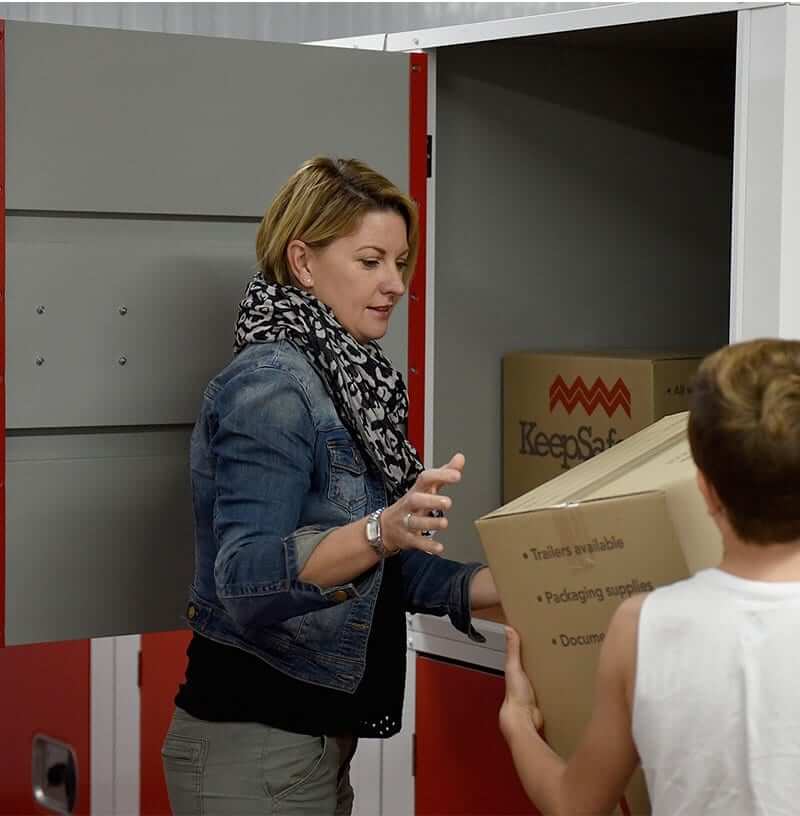women and boy backing keepsafe boxes into their small units