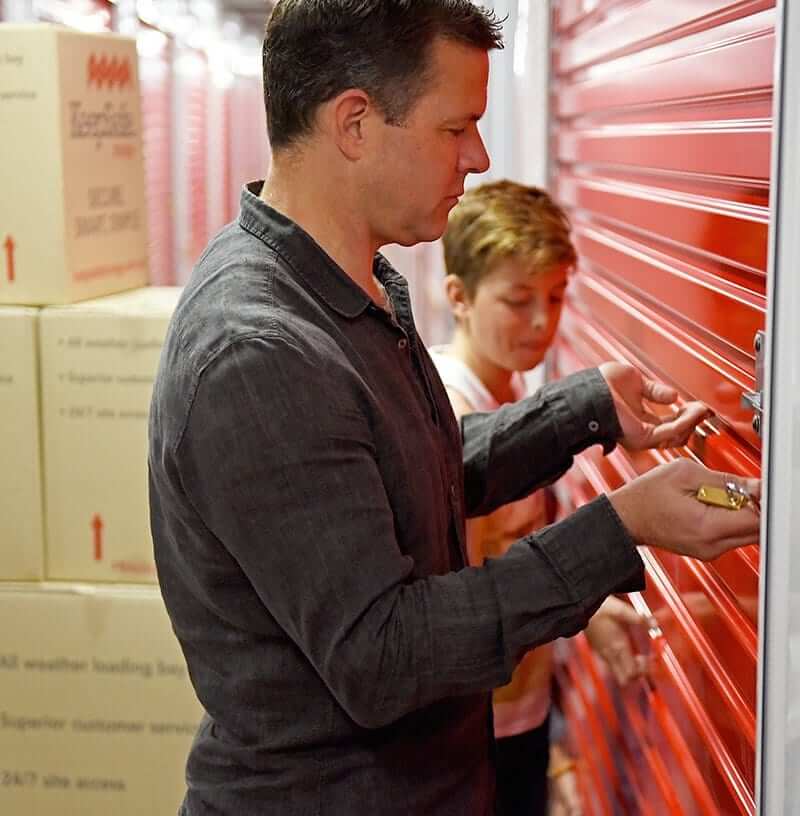 man and boy opening self storage unit with roller doors