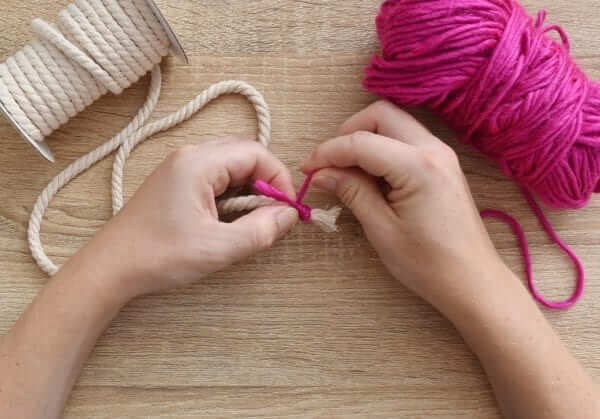 a person knotting yarn and rope together