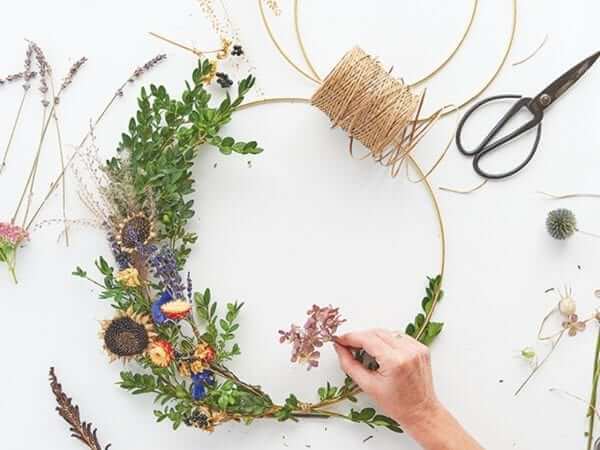 a woman crafting a floral wreath