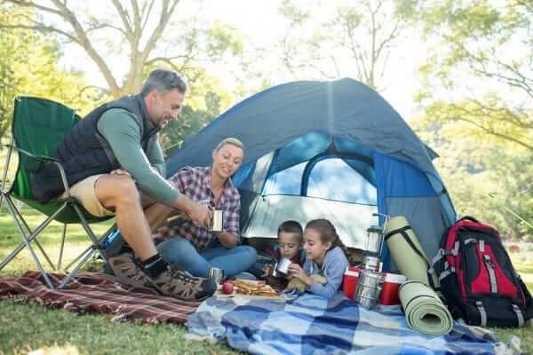 a family having snacks and coffee outside the tent