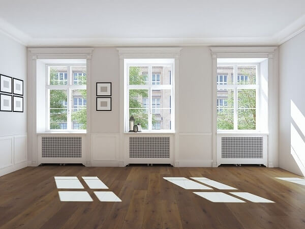 An empty room with three big windows installed in the walls
