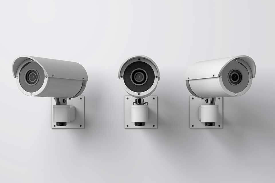 Three white surveillance cameras